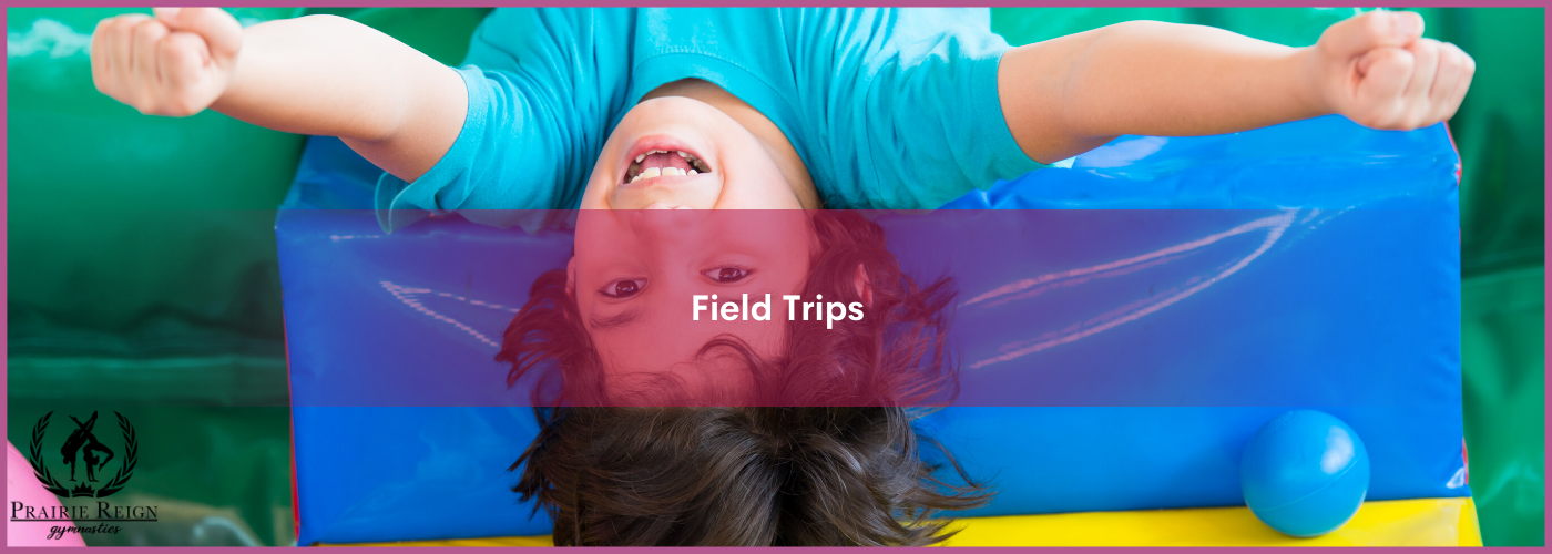 Smiling school-aged boy upside down over block at gymnastics