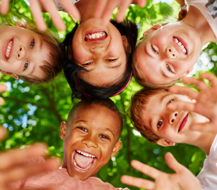 Laughing and smiling children's faces in a circle with tree background