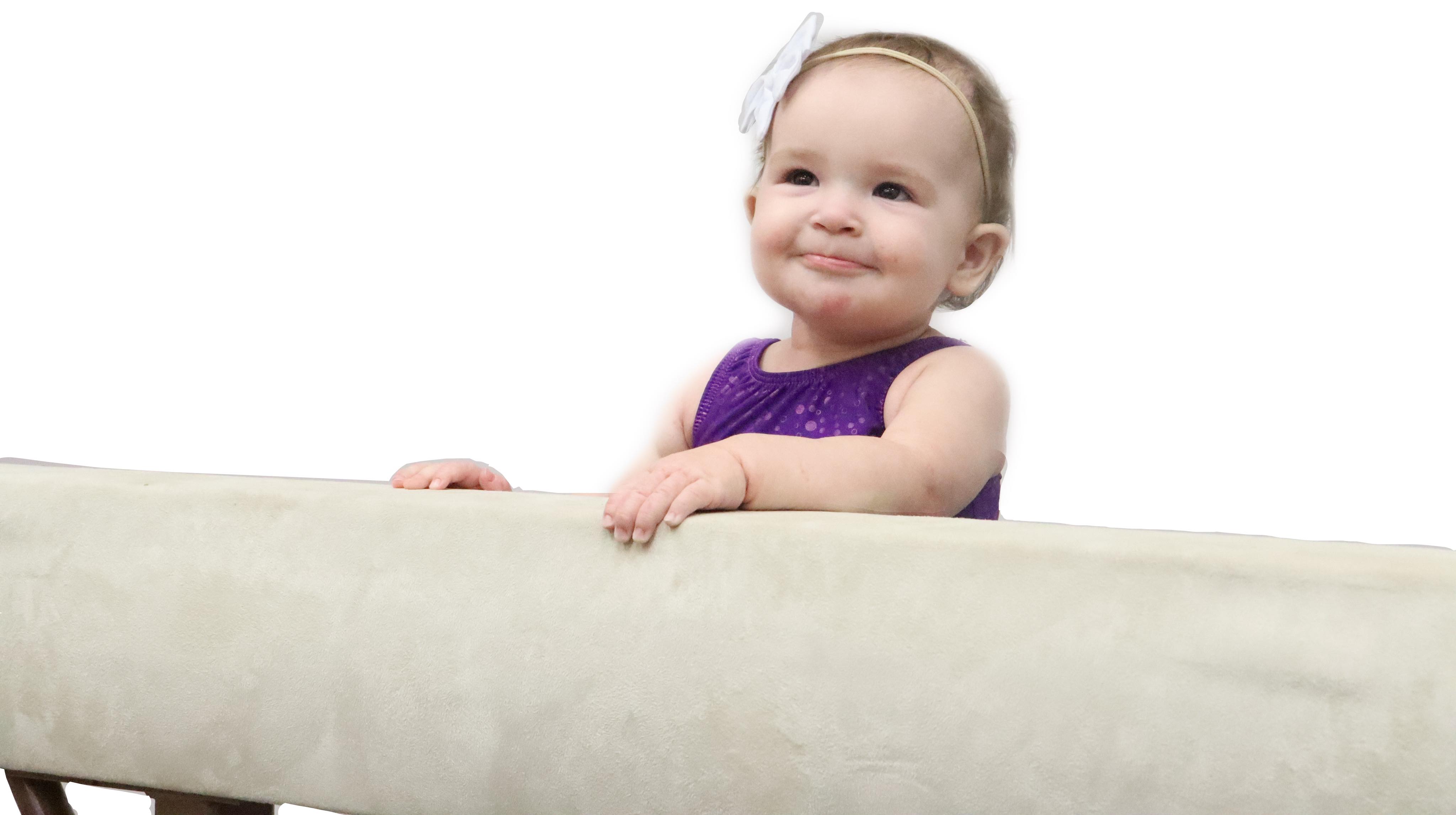 Happy toddler climbing onto balance beam